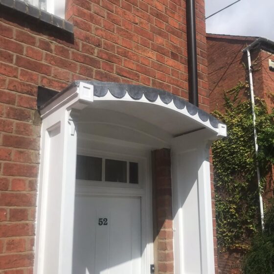 Red brick house with white front door and canopy.