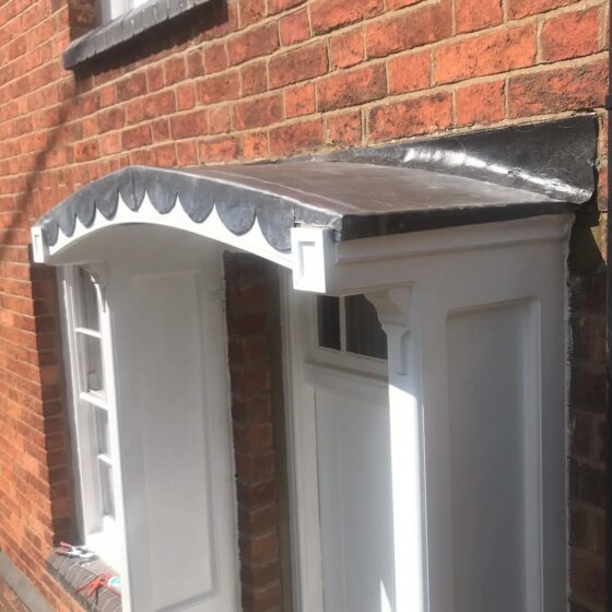 Close-up of front door canopy on brick house