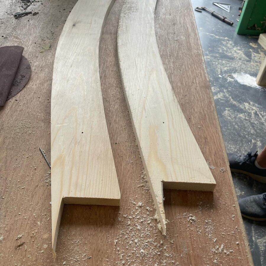 Two curved wooden planks on workbench