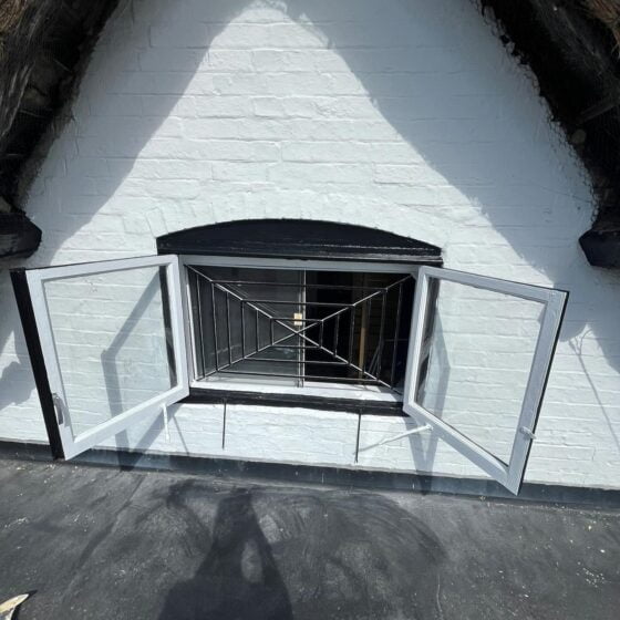 White brick window with open black metal grill.