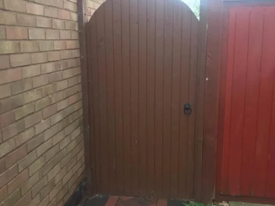 Wooden gate between brick walls