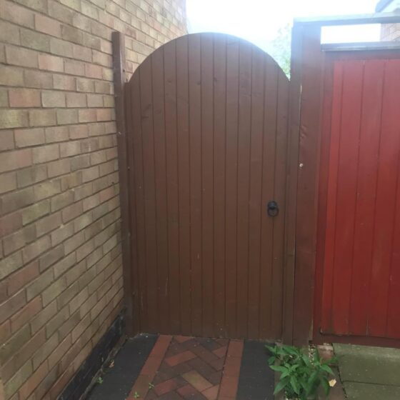 Wooden gate between brick walls