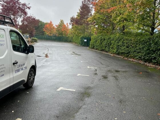 Empty car park with trees and a white van