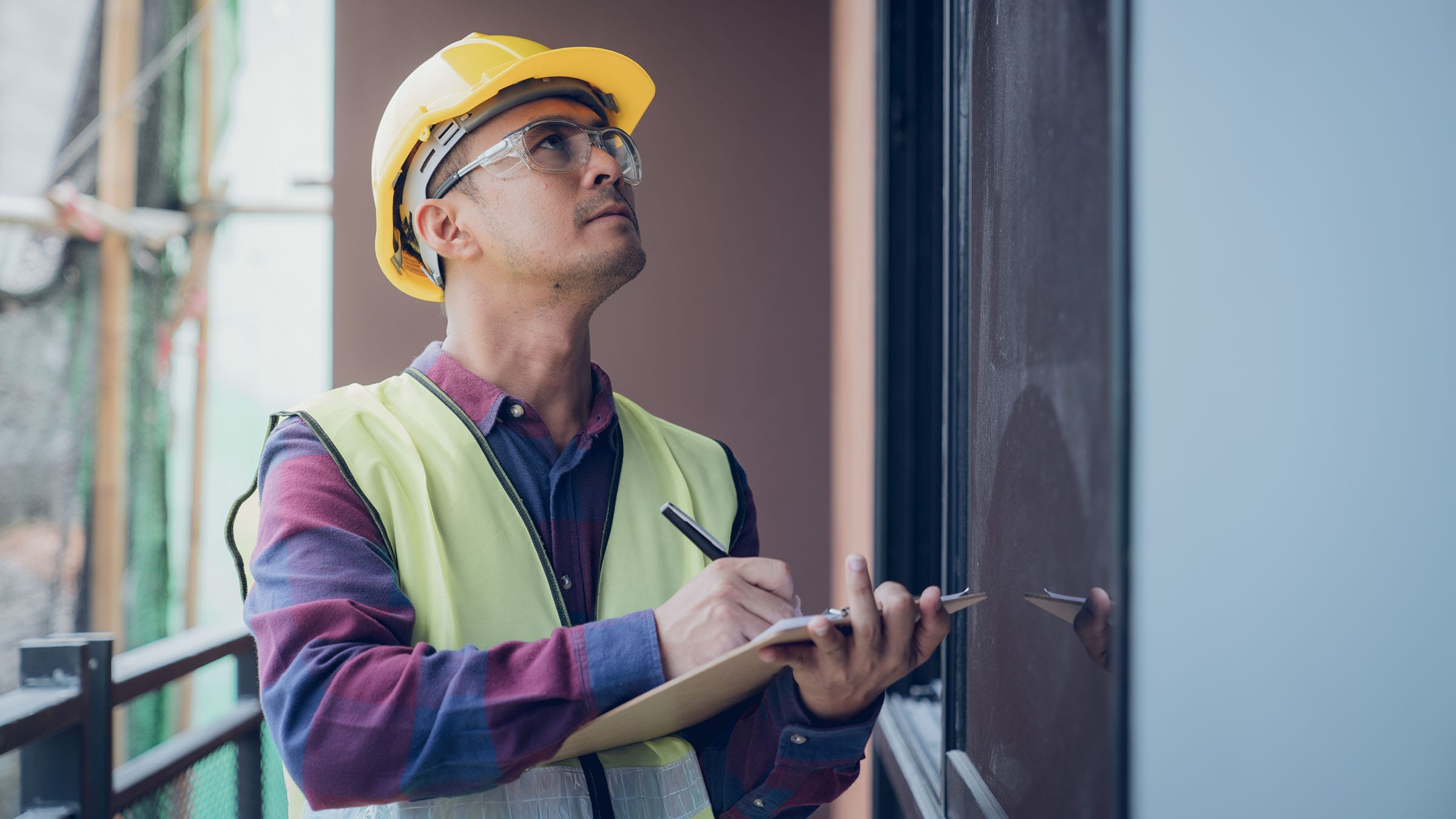 Engineer inspecting building site with clipboard